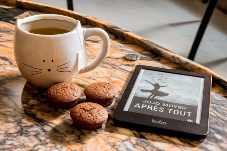 digital reader on a table with coffee cup and biscuits